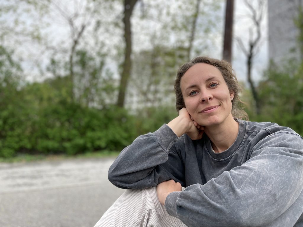Helena Zottmann sitzt auf einer Parkbank und freut sich über neue Text-Herausforderungen – Text, Lektorat, Konzept